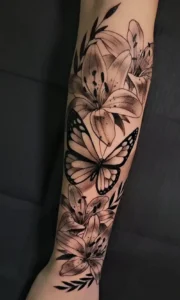 Tatuaje realista de flores y mariposas en Constance Tattoo en Valdemoro